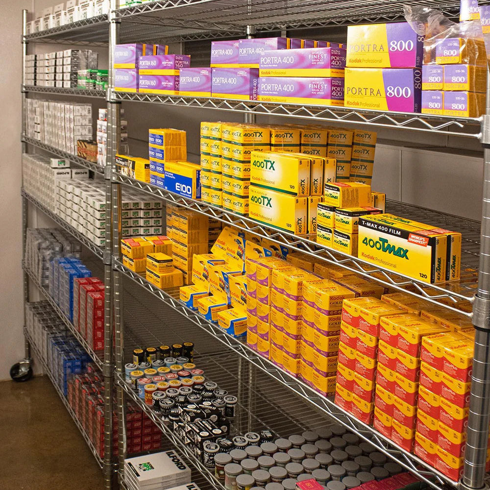 Storage shelves with various boxes and analog camera film in a warehouse setting