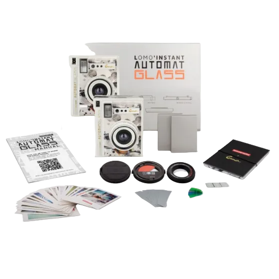 Lomo Instant Automat Glass film camera kit with accessories including a camera body, lens, filters, card holder, and instruction booklet on a white background.