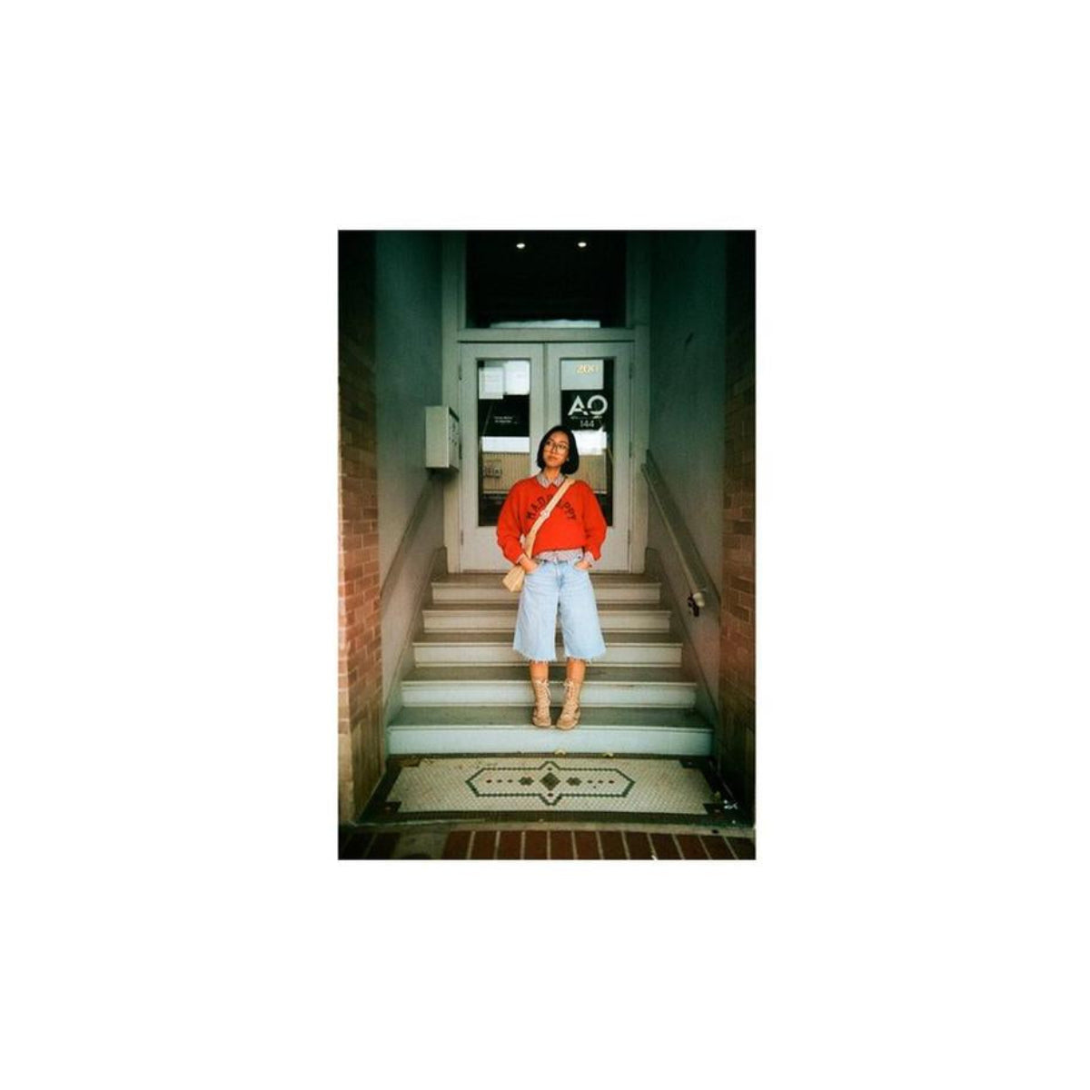 Person standing on stairs captured in a wide panoramic 35mm film frame with a vintage aesthetic.