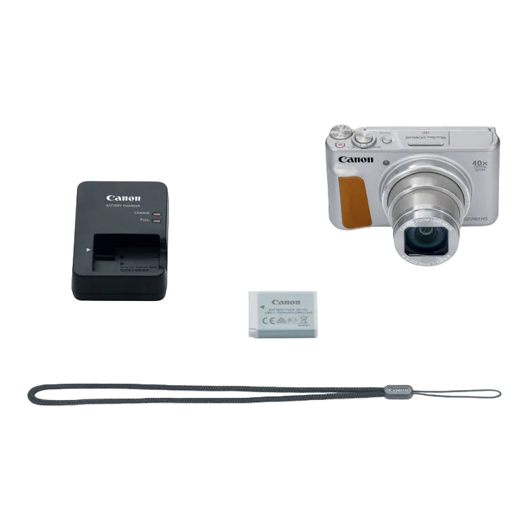 Canon digital camera with battery, charger, and strap on a white background