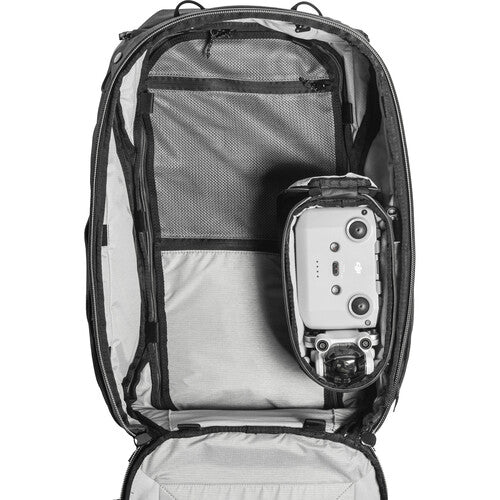 Camera equipment inside an open backpack on a white background