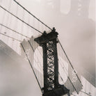 Close-up of a bridge's suspension tower with cables against a light background