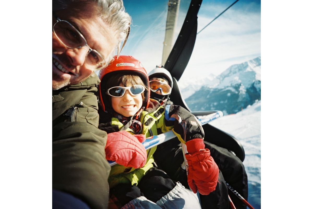 Two people in a helicopter with snowy mountains in the background