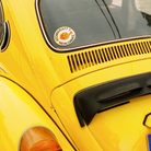 Yellow car with a sticker on the windshield