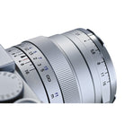 Close-up of a camera lens with focus and aperture scale on a white background