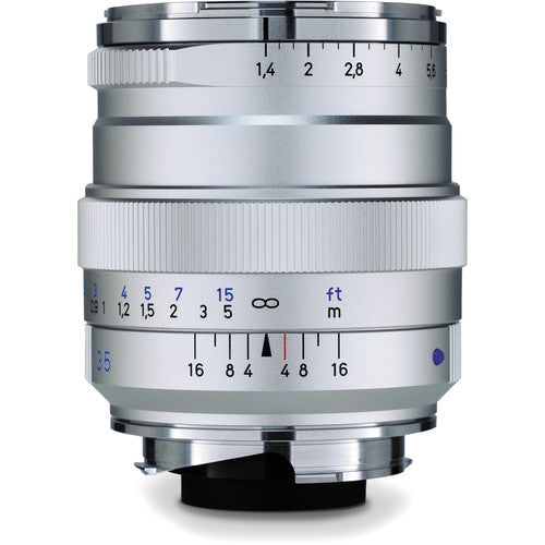 Silver camera lens with focus and aperture scale on a white background