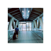Person walking through a modern, tungsten-lit pedestrian bridge, captured on Amber AHU T640 35mm color film.