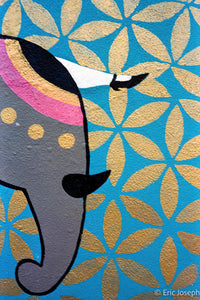 A close-up of a colorful elephant illustration on a blue background with a repeating gold floral pattern. The elephant is gray with pink, black, and white details, and the background has a metallic gold leaf texture.