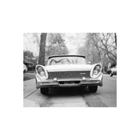 Black and white image of an older car with angled headlights