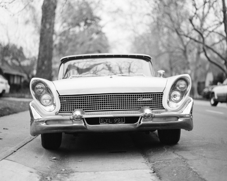 Black and white image of an older car with angled headlights
