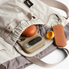 Close-up of a beige phone case with keychain and pumpkin on a white background