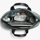Open Bellroy Totepack bag with laptop, documents, and personal items on a white background
