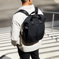 Person wearing a black Bellroy Totepack backpack on a city street