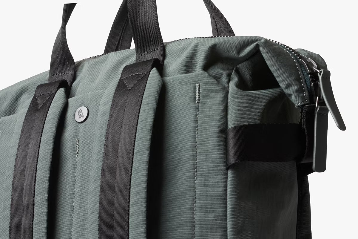 Green Bellroy Totepack bag with black straps on a white background