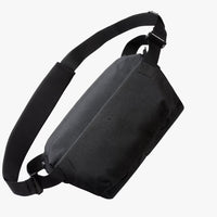 A black nylon sling bag with an adjustable shoulder strap, shown from a three-quarters perspective against a light gray background.