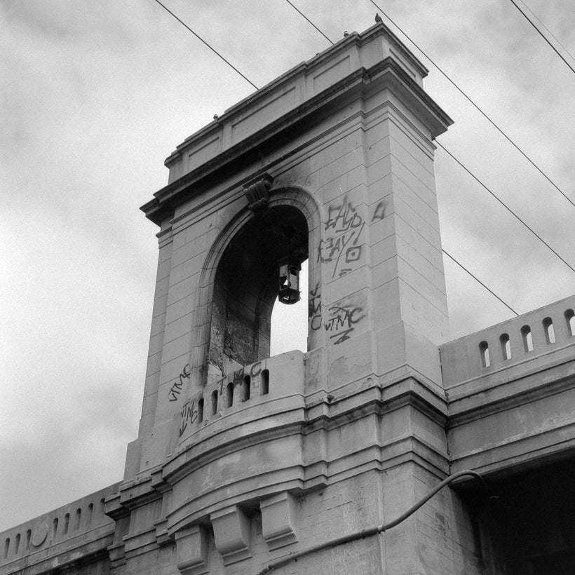 Black and white photograph of a bridge arch with graffiti, taken by Henry Keith.
