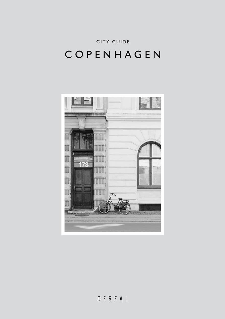 City guide to Copenhagen with a black and white photo of a building and bicycle on a light gray background.