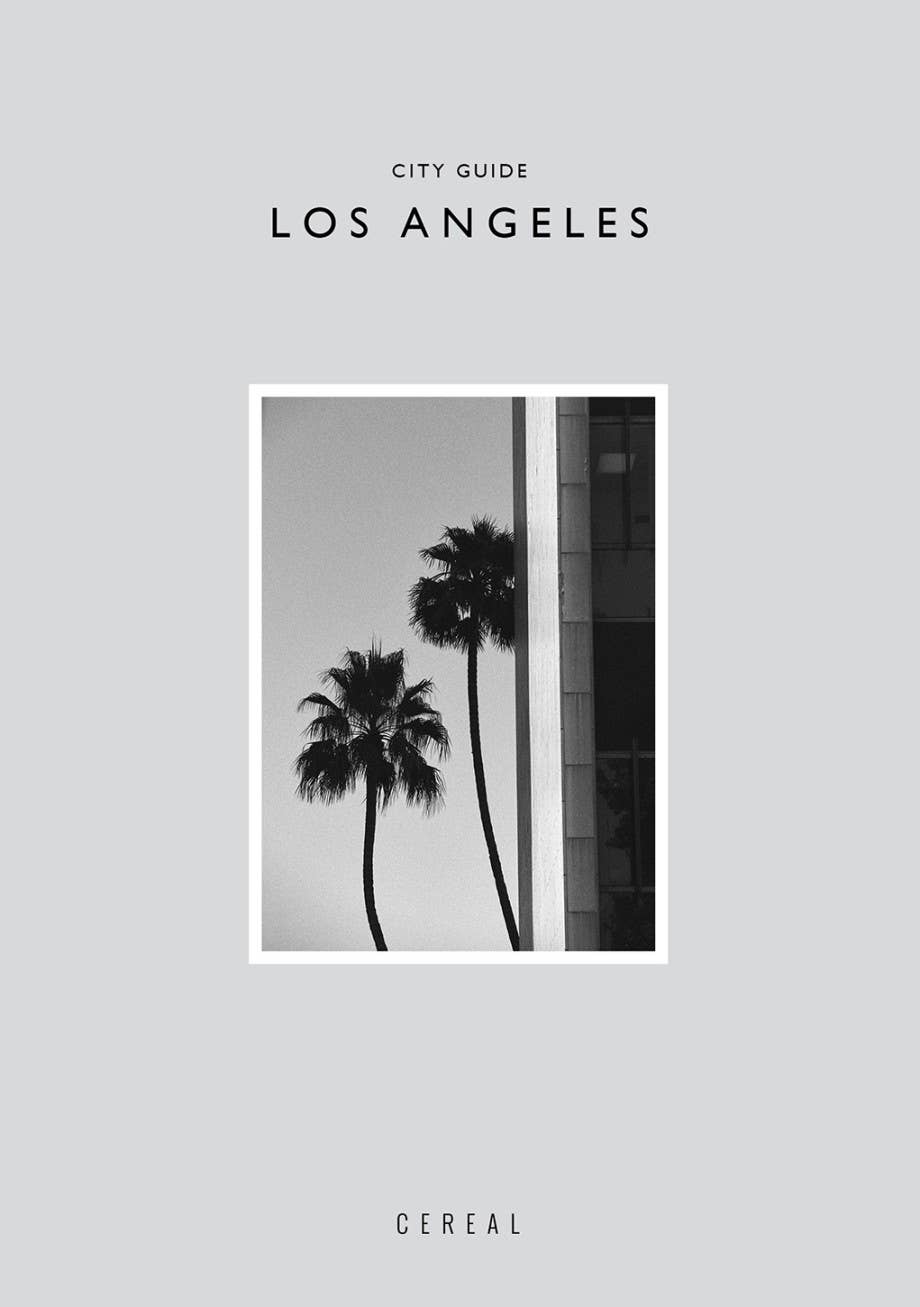 Cover of a city guide to Los Angeles featuring palm trees and a building on a gray background.