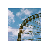 Ferris wheel against a bright blue sky, captured with vivid colors and fine grain on Candido 200 35mm color film.