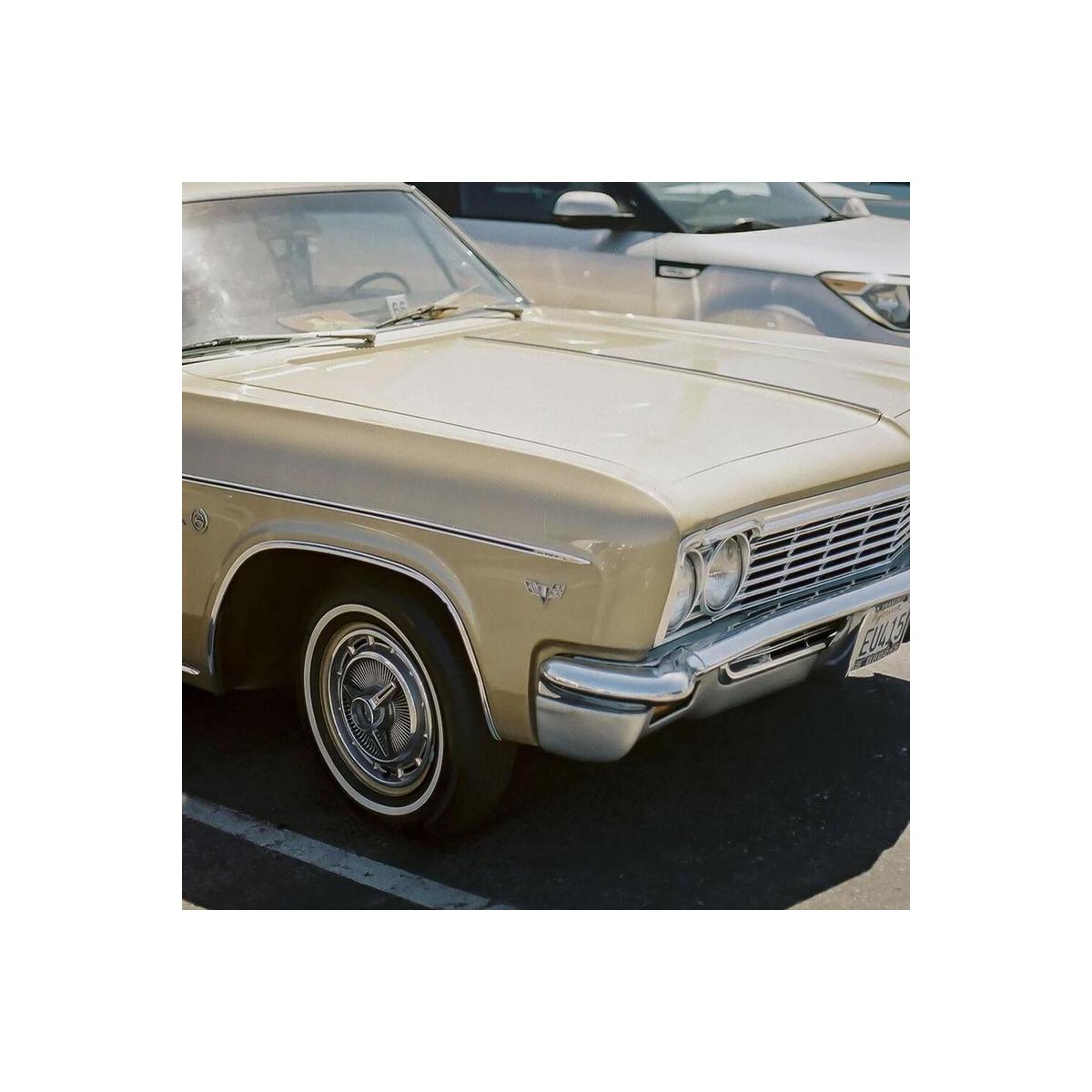 Vintage gold sedan parked outdoors, captured with the vivid colors and sharp detail of Candido 400 35mm film.