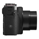 Black digital camera with textured grip and lens on a white background