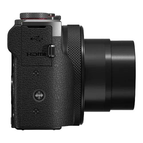 Black digital camera with textured grip and lens on a white background
