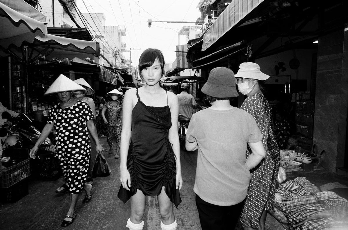 Black and White photo of woman in a black dress in an asian market
