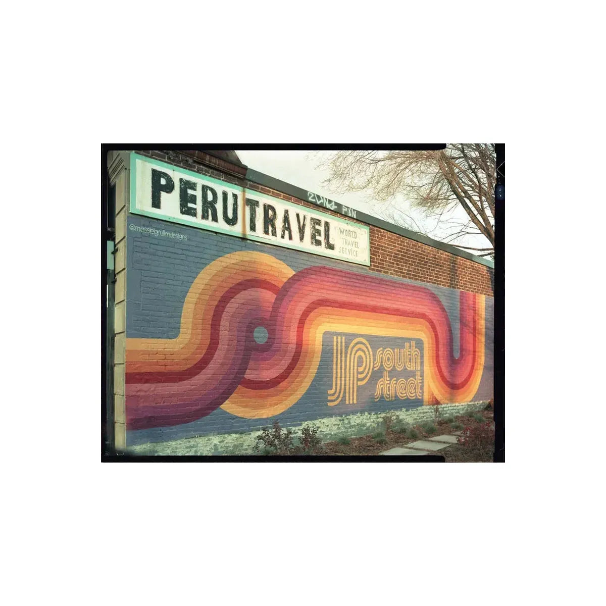 Colorful mural on a building with 'Peru Travel' sign above it