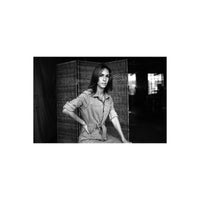 Portrait of a woman in a jumpsuit captured in sharp, high-contrast black and white film with rich gray tones.