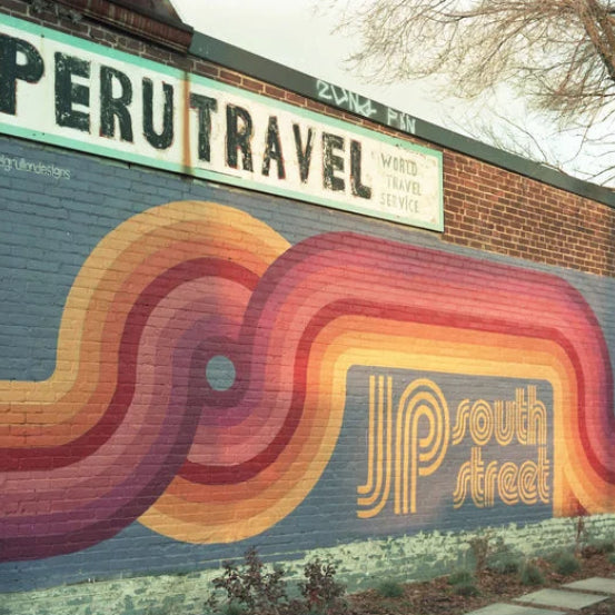 Colorful mural on a building with 'Peru Travel' sign above it