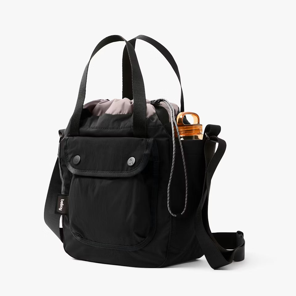 Black backpack with a water bottle and pink item on a white background