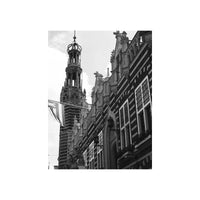 Black and white architectural photograph of historic European buildings, featuring a prominent tower and ornate facades, presented as a vertical print on a white background.