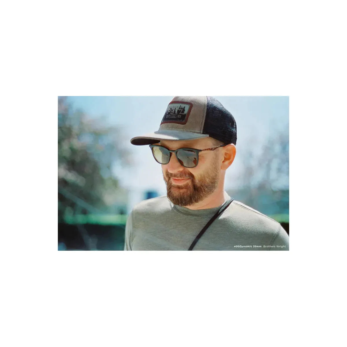 Man with a beard wearing a baseball cap and sunglasses, captured on CineStill 400Dynamic 35mm film with warm, natural tones.