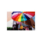 Person under a vibrant rainbow-colored umbrella, captured with CineStill 400Dynamic 35mm film showing warm tones.
