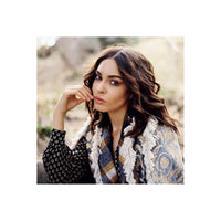 Portrait of a woman with wavy brown hair wearing a patterned shawl, captured with fine grain and warm daylight tones.