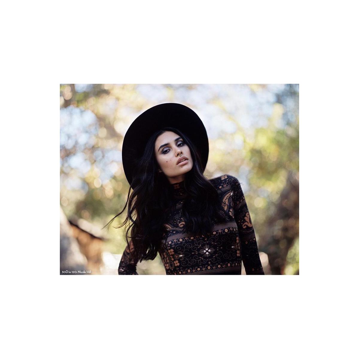 Woman in a black hat and patterned top shot on CineStill 50Daylight 120 film with soft, natural bokeh background.
