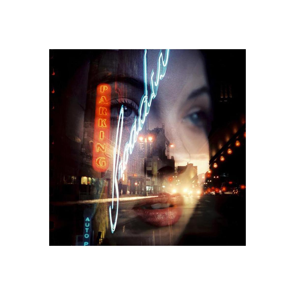 Double exposure of a woman's face and a neon-lit city street captured on CineStill 800T tungsten film.