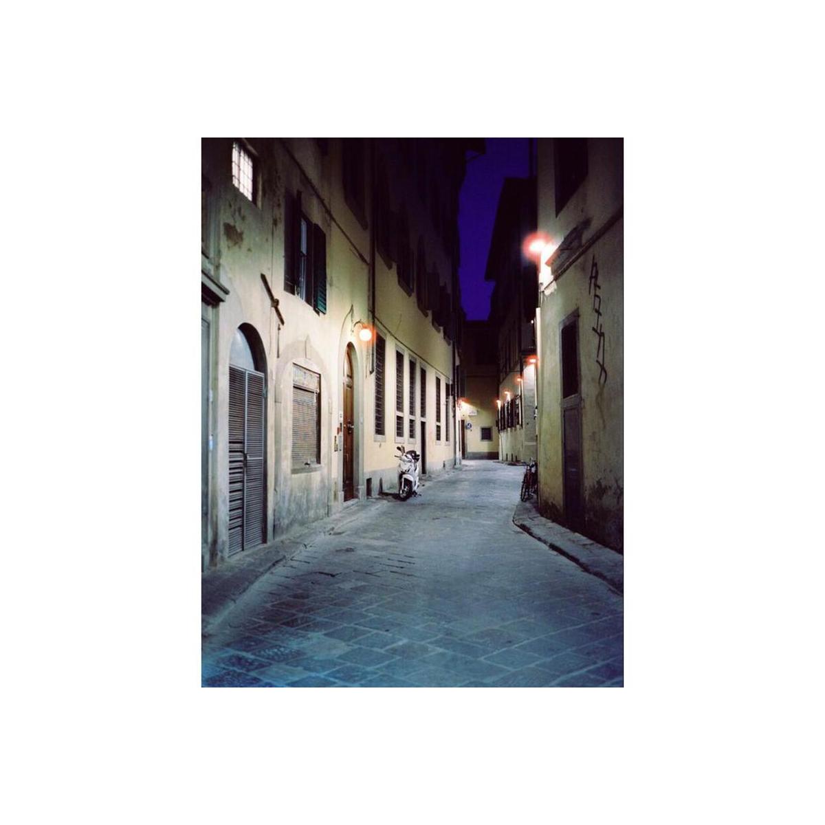 Narrow cobblestone alley at night with signature CineStill 800T tungsten-balanced blue tones and glowing streetlights.