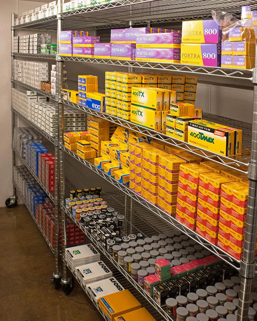 Storage shelves with various boxes and analog camera film in a warehouse setting