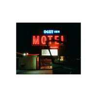 A nighttime photograph of a lit 'Budget Inn Motel' neon sign, with a dark car silhouette in the foreground and a white border at the top and bottom.
