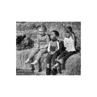 Three children sitting on hay bales, captured in sharp, high-contrast black and white using FPP Derev Pan 400 film.