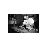 Man playing a Nord Electro 2 keyboard in a studio, captured on high-contrast black and white 35mm film.