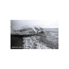 Black and white landscape shot of an icy shoreline with frozen rock formations and ocean waves, captured on 35mm film.