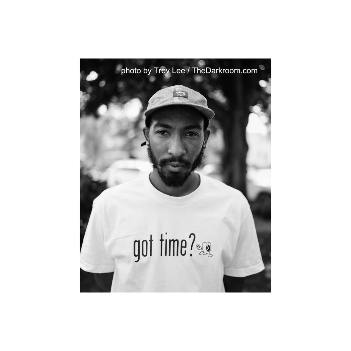 Black and white portrait of a man wearing a cap and t-shirt, captured on FPP Wolfman 100 ISO 120 film with classic grain.