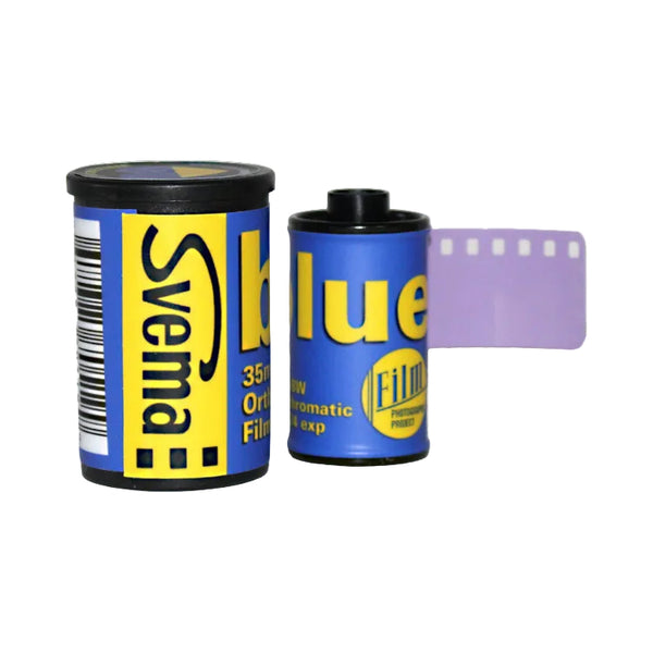 Two Swema brand blue film canisters with a purple film strip extending from the right, on a plain white background.