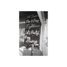Black and white film shot of neon script signs on a dark wall, capturing a moody, high-contrast aesthetic.