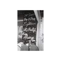 Black and white film shot of neon script signs on a dark wall, capturing a moody, high-contrast aesthetic.