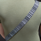 A camera strap with a multicolored pattern and black leather ends.