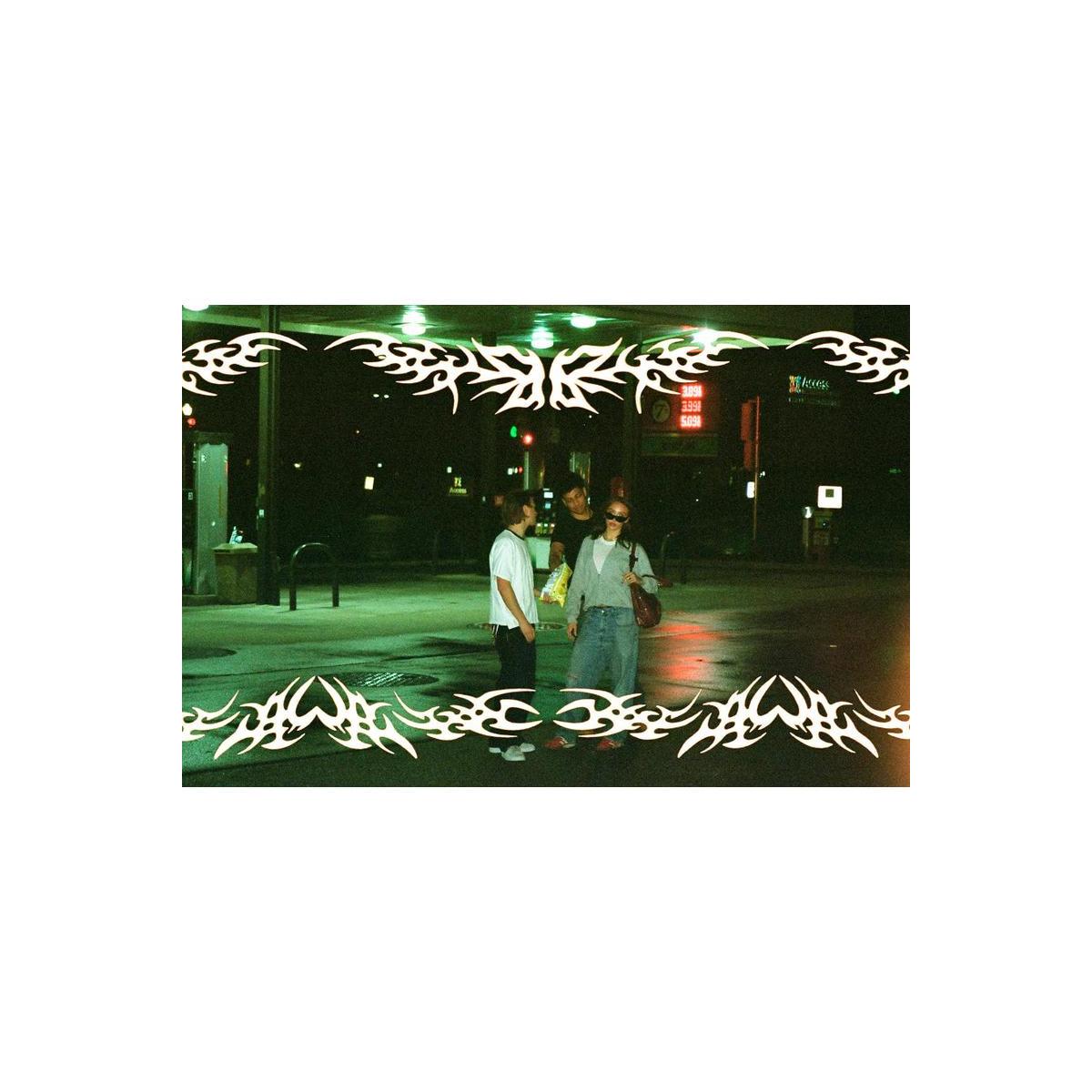 Three people standing at night outside a convenience store under green and red store lights, with a white tribal graphic border overlaying the top and bottom of the photo.