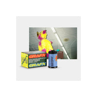 A GRAFX 35mm graphic overlay film box and a single roll of 'Shattered' series film displayed in front of a sample preview image showing a yellow and purple shredded piñata mask against a cracked ceiling background.